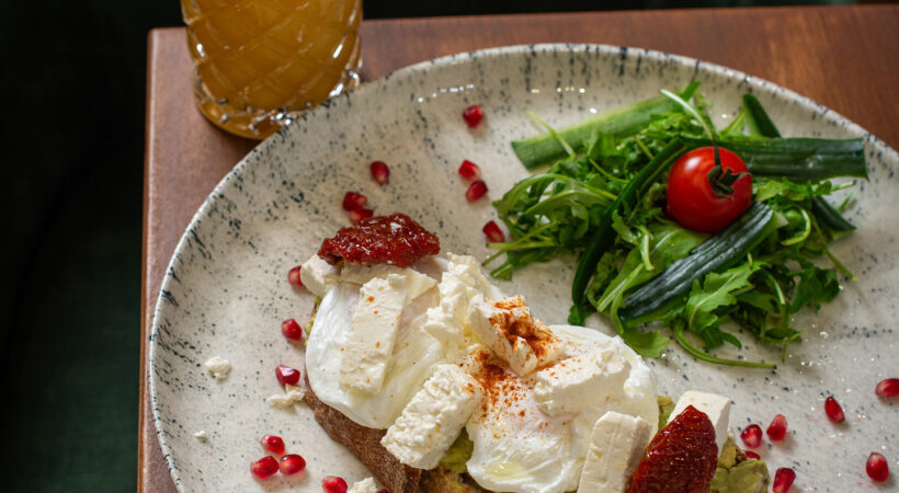 Poached eggs on toast with salad and an orange drink at Mila Loughton